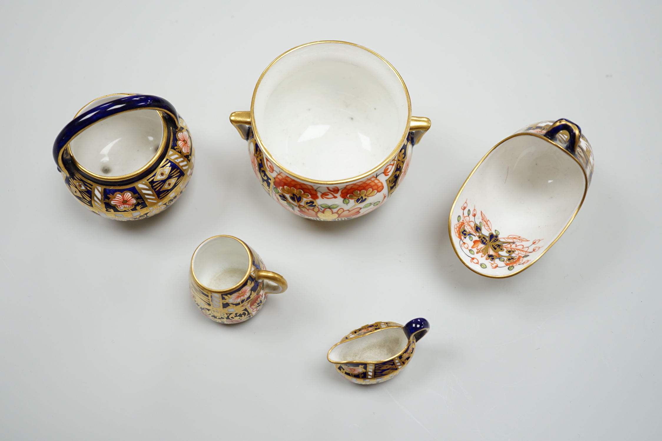 20th century Derby miniature wares in Imari patterns including a mug, a sauceboat, a cauldron, a large cauldron and a spoon warmer